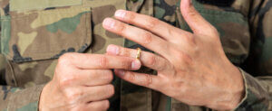 A man in the military takes off his wedding band